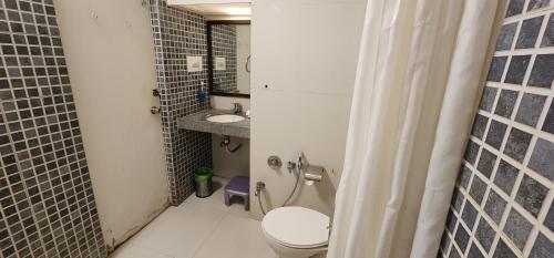 a small bathroom with a toilet and a sink at Hotel Kanak in Ahmedabad