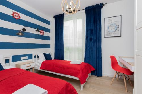sypialnia z 2 łóżkami i niebiesko-białymi paskami w obiekcie Apartment Redlowo & 2 bedrooms & Parking by Renters w mieście Gdynia