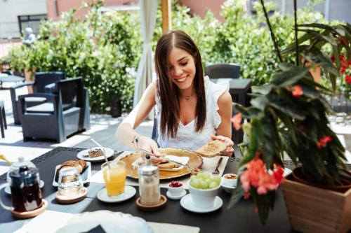 a woman is sitting at a table eating food at BioBenessere Eco-B&B -Adults Only- Moto&Bike Parking in Arezzo