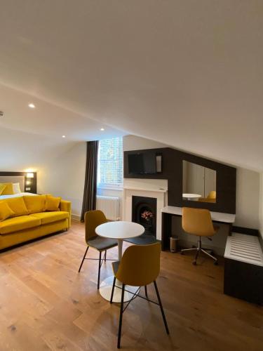 a living room with a yellow couch and a table at Notting Hill House in London