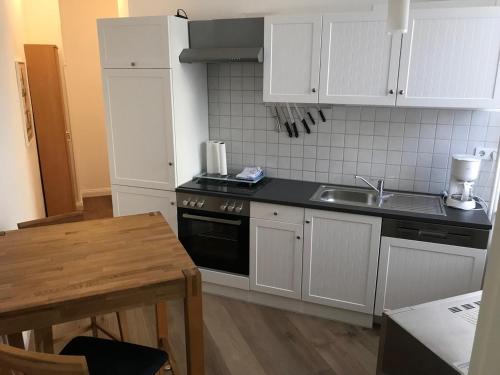 a kitchen with a stove and a sink and a table at Möbiliertes wohnen auf dem Sandberg in Flensburg