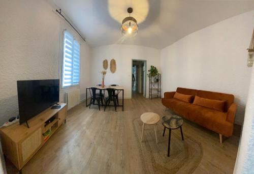 a living room with a couch and a tv at La Suite des Platanes in Perpignan