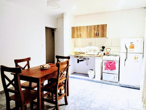 a kitchen with a table and chairs and a refrigerator at Arizona in Chascomús