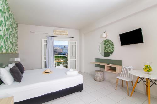 a bedroom with a bed and a table and a tv at Sunshine Studios in Malia