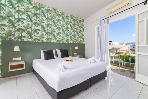 a bedroom with a bed and a large window at Sunshine Studios in Malia