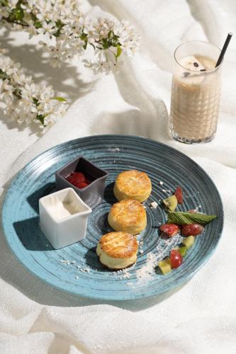 a blue plate with biscuits and fruit and a drink at Žilvinas Hotel in Palanga
