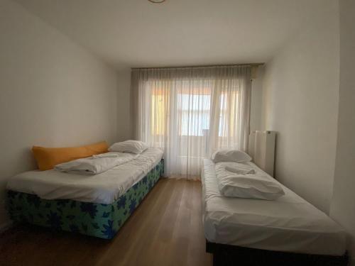 two beds in a small room with a window at Schwalbacher Residenz in Frankfurt/Main