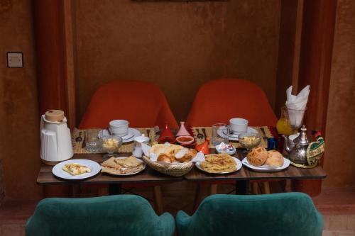 a table with food on it with two chairs at Riad Le Plein Sud in Marrakech