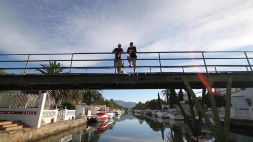 two people standing on a bridge over a river at Hotel Castell Blanc in Empuriabrava