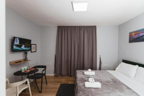 um quarto de hotel com uma cama e uma mesa com uma mesa em New Studio near New Bazaar - Tirana City Center em Tirana