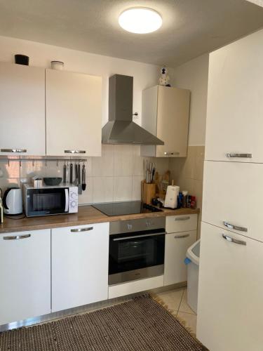 a kitchen with white cabinets and a stove top oven at House Bartulović in Brela