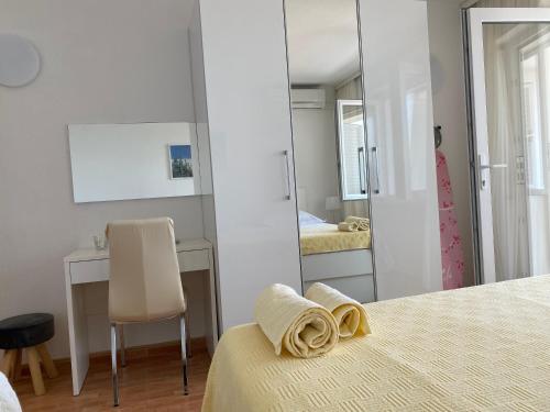 a bedroom with a mirror and a bed and a chair at House Bartulović in Brela