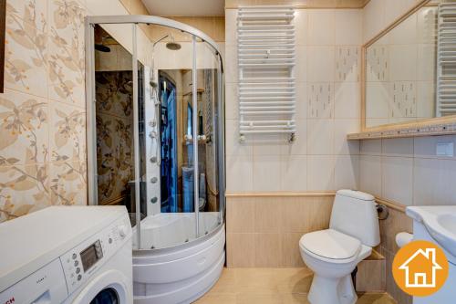 a bathroom with a toilet and a shower and a sink at Apartamenty Platan - visitopl in Świnoujście