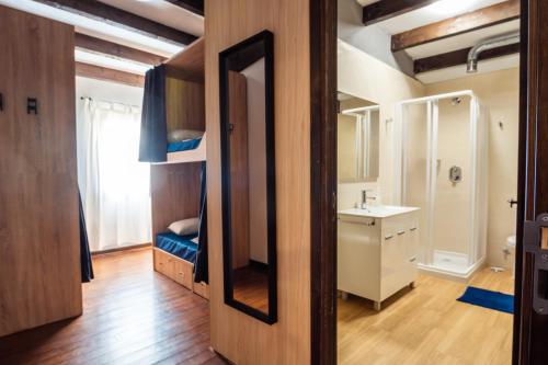 a bathroom with a bunk bed and a mirror at Albergue GBC Caldas in Caldas de Reis