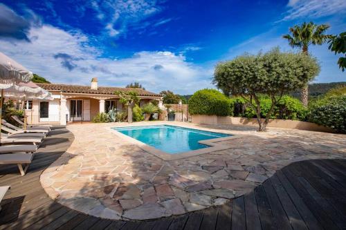 une cour arrière avec une piscine et une maison dans l'établissement Villa Pastel, à Gassin