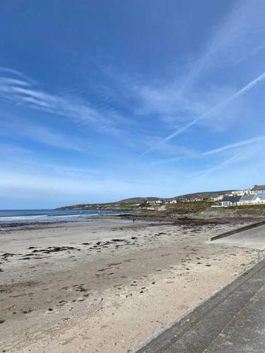 a beach with a blue sky and the ocean at Luxury holiday rental with sea views on the Wild Atlantic Way in Tralee