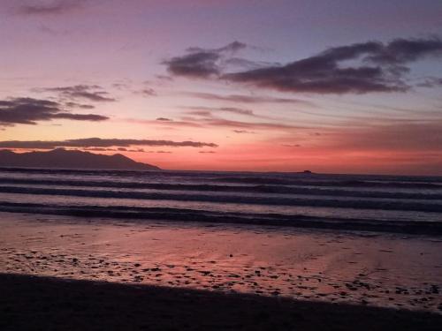 a sunset on a beach with the ocean at Luxury holiday rental with sea views on the Wild Atlantic Way in Tralee