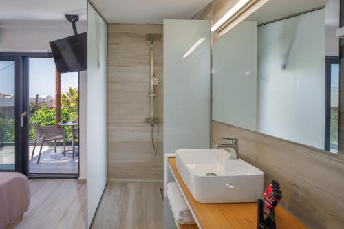 La salle de bains est pourvue d'un lavabo et d'un miroir. dans l'établissement Hermagio Villa Mary by Estia, à Mália