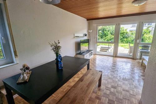 uma sala de estar com uma mesa preta com flores em Reiheneckhaus mit Garten und Terasse em Tettnang