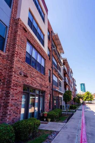 a red brick building on a sidewalk next to a street at Cowtown 1 bedroom Downtown FTW in Fort Worth