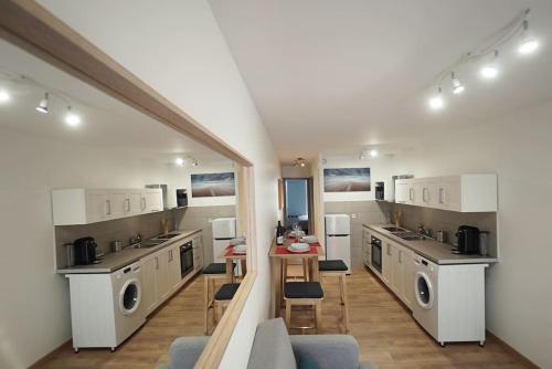 une grande cuisine avec machines à laver et une table dans l'établissement Le calme d'un joli patio en centre-ville, à Sète