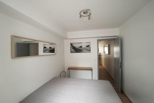 Cette chambre blanche dispose d'une table et d'une porte. dans l'établissement Le calme d'un joli patio en centre-ville, à Sète