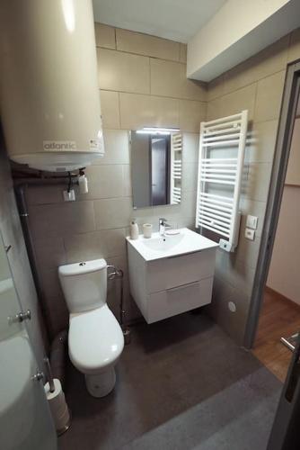 une salle de bain avec des toilettes blanches et un lavabo dans l'établissement Le calme d'un joli patio en centre-ville, à Sète