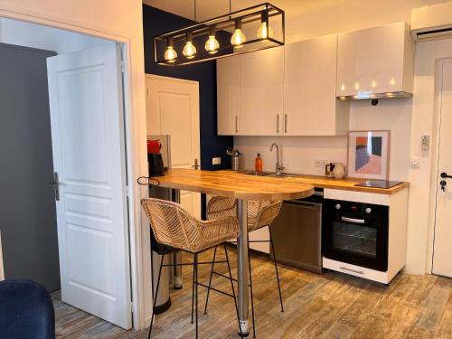 une cuisine avec une table en bois et quelques chaises dans l'établissement Le panier de Clarisse, à Marseille