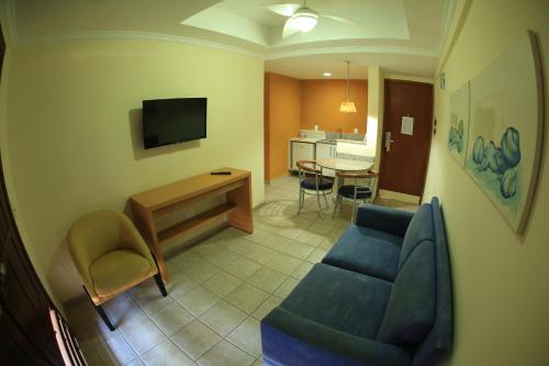 a living room with a blue couch and a table at Garbos Soleil Hotel in Natal