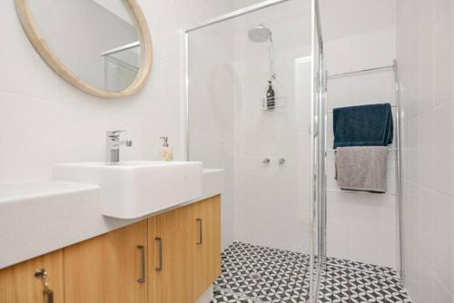 a bathroom with a sink and a shower with a mirror at Saltys 4BRM Beachfront WIFI Pet Friendly in Victor Harbor