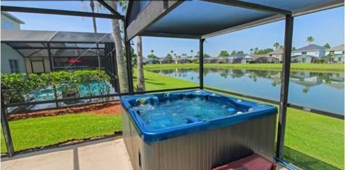 a hot tub on a patio with a view of a lake at Sunny South Facing Pool with Hot Tub and Lake View Near Disney in Kissimmee