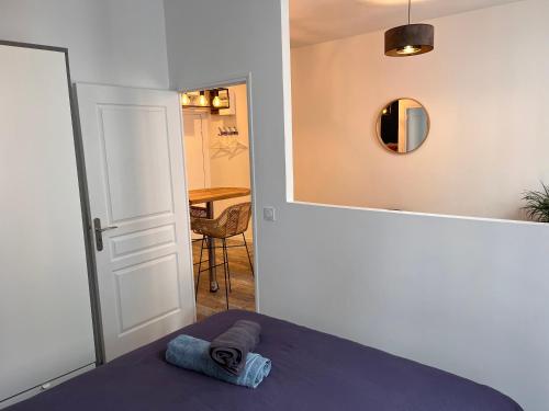 - une chambre avec un lit, un miroir et une table dans l'établissement Le panier de Clarisse, à Marseille
