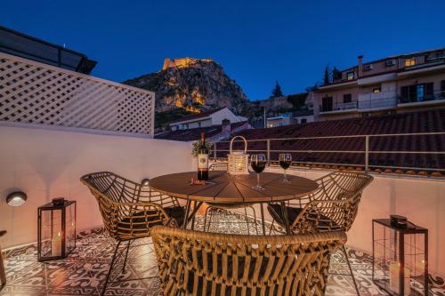 a table and chairs on a balcony with a mountain at Kastro Residence in Nafplio