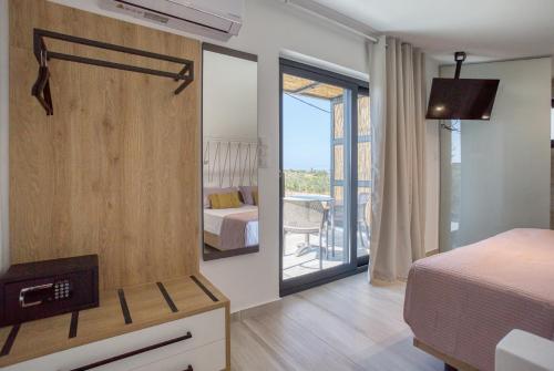 a bedroom with a bed and a view of a room at Hermagio Villa Mary by Estia in Malia