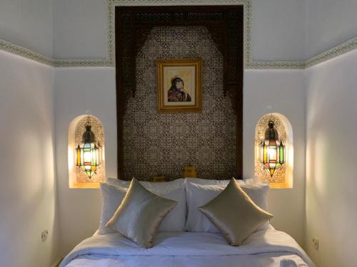 ein Schlafzimmer mit einem Bett mit zwei Leuchten darüber in der Unterkunft Riad Malida Marrakech in Marrakesch
