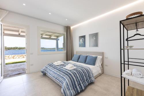 a bedroom with a bed and a view of the water at Baia del Sole in Olbia