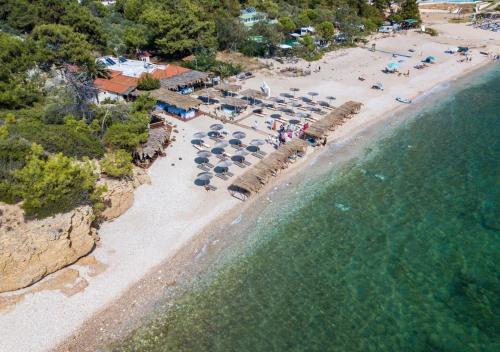 an aerial view of a beach with umbrellas and the ocean at Oasis Deluxe Studios in Pefkari