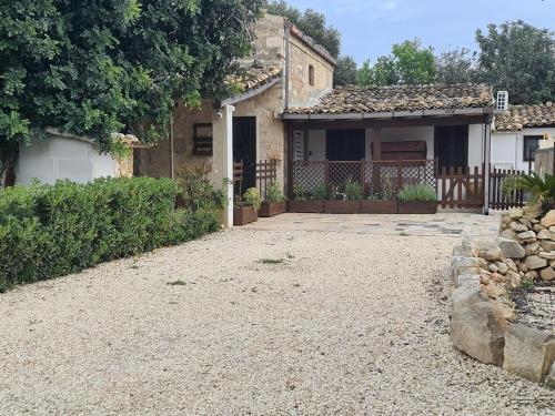 a house with a gravel driveway in front of it at La Casetta in Santa Croce Camerina