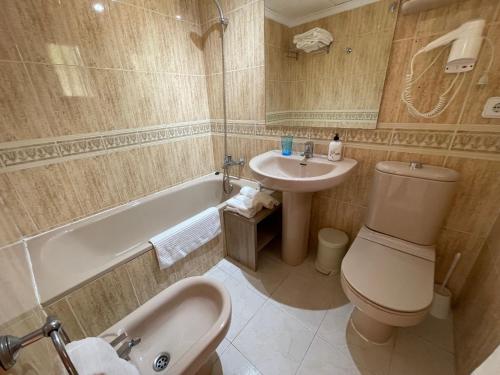 a bathroom with a sink and a toilet and a bath tub at Pool paradise in Calpe