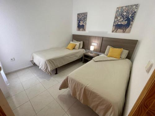 a bedroom with two beds and a table with a lamp at Pool paradise in Calpe