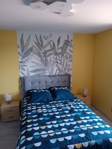 - une chambre avec un lit bleu et une fresque murale dans l'établissement La bulle beaujolaise, à Juliénas