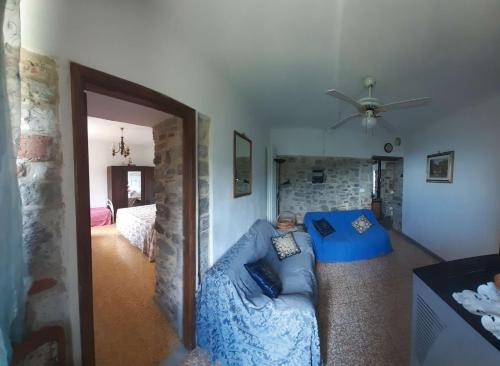 ein Wohnzimmer mit einem blauen Sofa und einem Deckenventilator in der Unterkunft Montedivalli in Montedivalli Chiesa