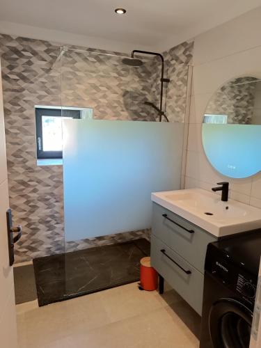 une salle de bain avec un lavabo et un miroir dans l'établissement La bulle beaujolaise, à Juliénas