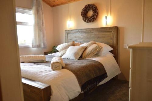 a bedroom with a large bed with a wreath on the wall at Lochhill Stable Lodge in Castle Douglas