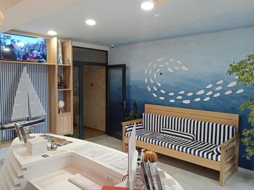 sala de estar con sofá y pared con pintura en Navigator en Palić