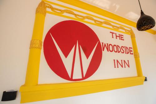 a sign for the wodonga inn on a wall at The Woodside Inn in Benaulim