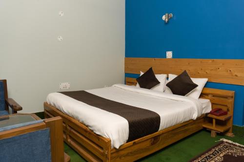 1 dormitorio con 1 cama con pared azul en The Hill Paradise, en Almora