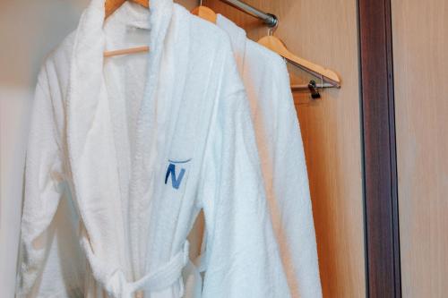 a white robe is hanging on a rack at Novotel Trabzon in Trabzon