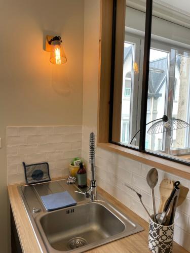 a sink in a kitchen with a window and a counter at Appartement Le Fayot in Wimereux