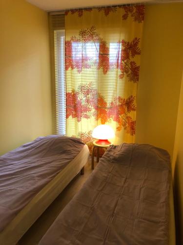 a bedroom with a bed and a window with a lamp at Upea kohde Näsijärven rannassa in Tampere